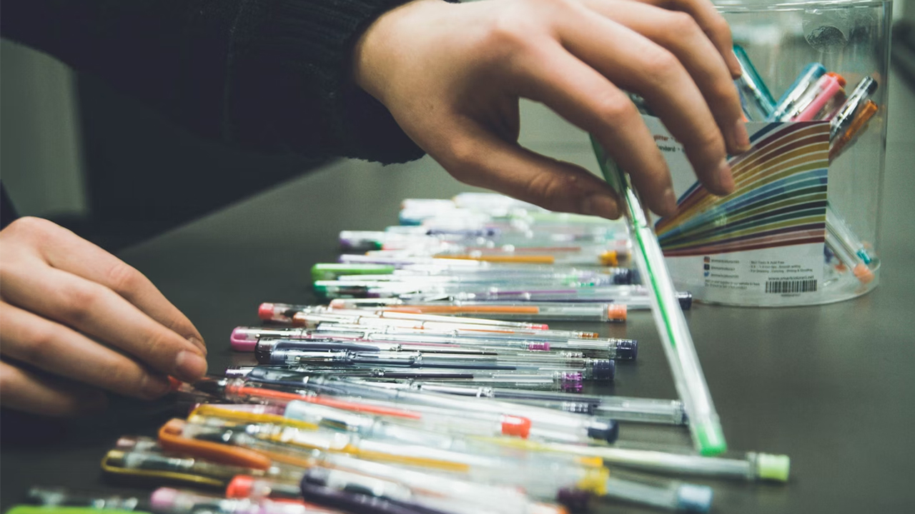 desk setup for writing or studying, quick access to frequently used pens, organized workspace in an office or student environment, ready for note-taking or journaling session