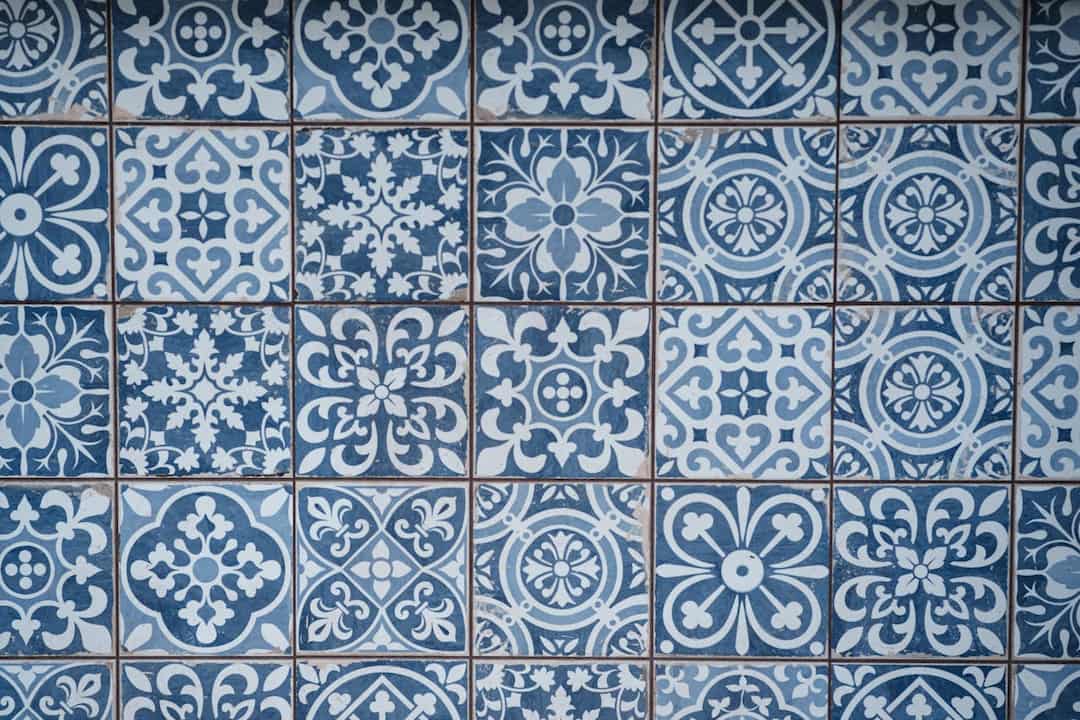 blue and white ceramic tiles, various floral and geometric patterns, square layout, traditional Mediterranean style, slight wear visible