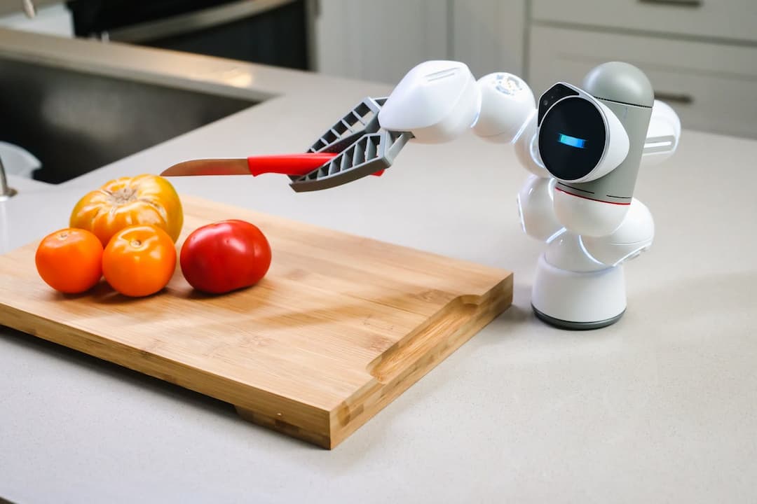 robot arm holding knife, tomatoes on wooden cutting board, modern kitchen background